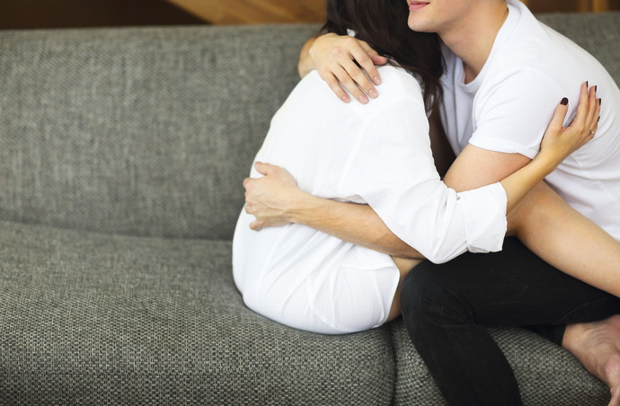Brunette woman and man lying and hugging. The concept of tenderness and love
