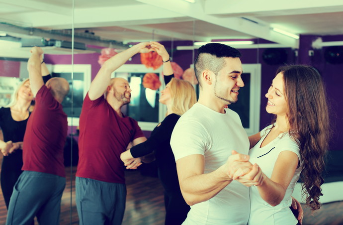 Happy young healthy people having dancing class indoors