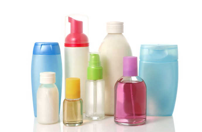 Blank bottles of shampoo, conditioner, perfume and pink salt over white background