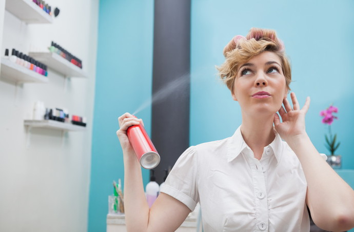 Customer using hair spray to style hair